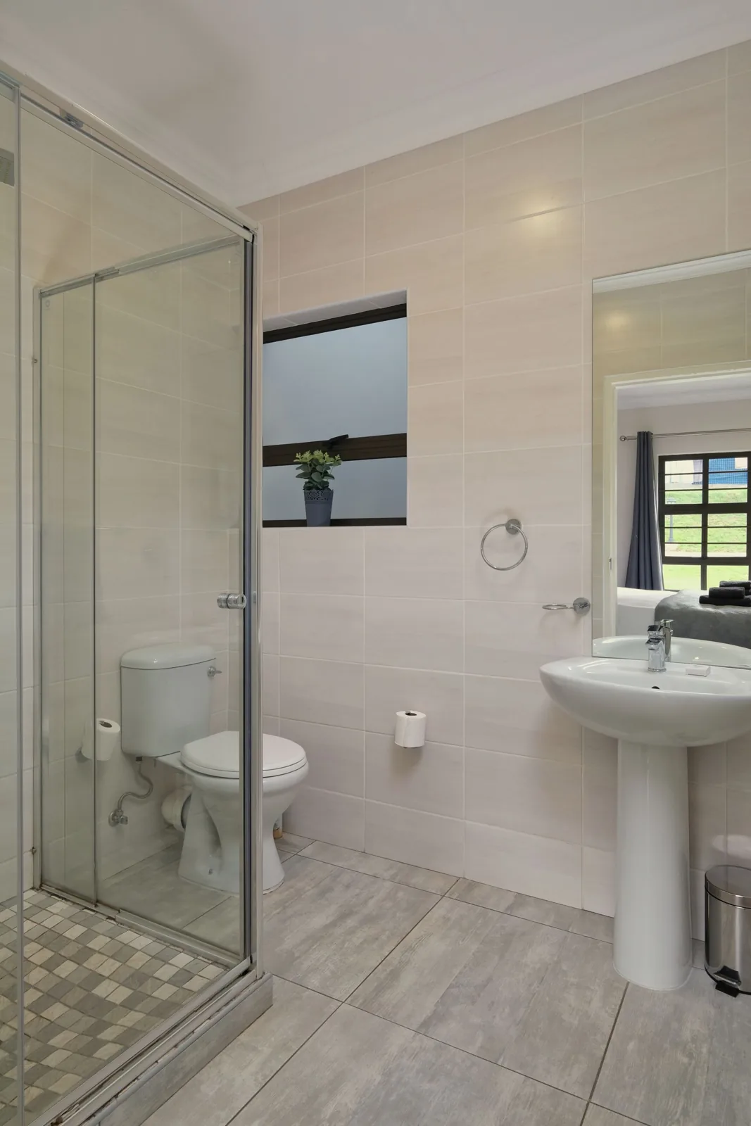 Compact bathroom with basin, toilet and glass shower enclosure